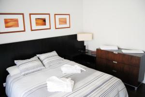 a bedroom with a bed with two towels on it at Facing the Sea in Furadouro +22 photos