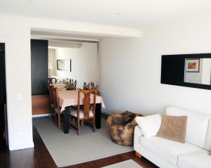 a living room with a table and a white couch at Facing the Sea in Furadouro