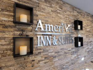 een stenen muur met een bord dat Amerikaanse herberg en suites leest bij AmeriVu Inn and Suites - Chisago City in Chisago City