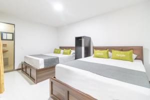 1 dormitorio con 2 camas y espejo en Hotel Ayenda 1086 Torre 52, en Bogotá