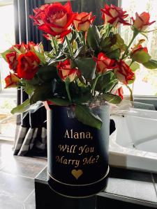 a vase with a bouquet of roses in it at Spa Suites at RAVEN in Hepburn Springs