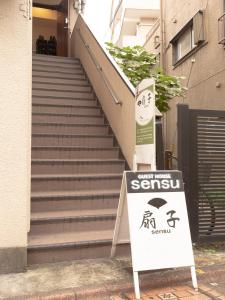a sign in front of a stairs with a sign for a senucu at Guesthouse Sensu in Tokyo