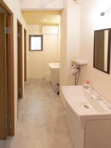 a white bathroom with a sink and a toilet at Guesthouse Sensu in Tokyo
