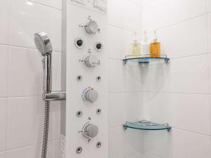 a white bathroom with a shower and shelves on the wall at HOTEL FORZA SAPPORO STATION in Sapporo