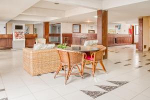 OYO Hotel Oceanico Armacao في سلفادور: مطبخ وغرفة معيشة مع طاولة وكراسي