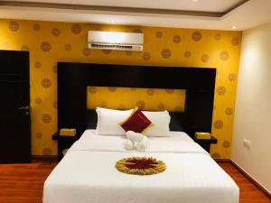 أول سويت في الرياض: غرفة نوم بسرير ابيض كبير وبجدار اصفر