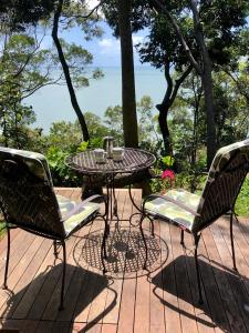 uma mesa de pátio e cadeiras num deque em Gunnadoo Holiday Hut with Ocean Views and Jacuzzi em Miallo