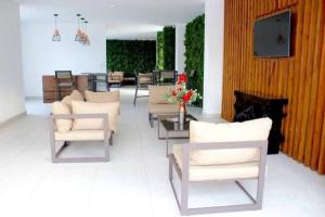 a living room with chairs and a table and a fireplace at Lujoso y acogedor condominio ejecutivo/familiar in San Pedro Sula