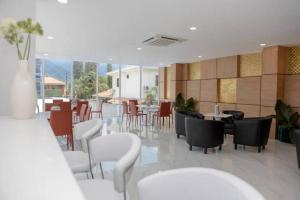 圣佩德罗苏拉Lujoso y acogedor condominio ejecutivo/familiar的一间设有白色桌椅的餐厅和一间自助餐厅