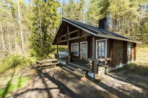 uma cabana de madeira no meio da floresta em Rantamökki Onni em Hämeenlinna