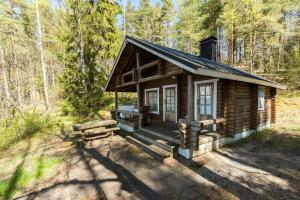 une cabane en rondins au milieu des bois dans l'établissement Rantamökki Onni, à Hämeenlinna