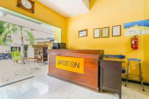 a reception desk in a room with a sign on it at SPOT ON 2422 Hotel Moga Sari in Situbondo