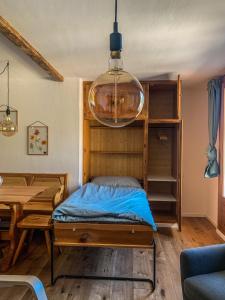 a bedroom with a bed and a table and a chandelier at Ferienwohnung in den Bergen mit grosser Terrasse in Bivio