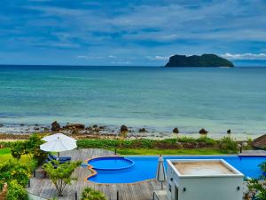 uma vista para a praia a partir da varanda de um resort em The Beach Resort & Residence - SHA Plus em Pathiu