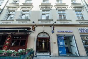 um edifício branco com uma entrada para uma loja em Hotel Rezydent em Cracóvia