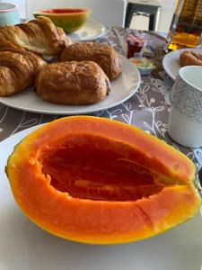 a peach sitting on a table next to plates of pastries at Tara Tahiti Lodge in Taunoa