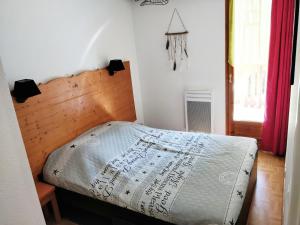 ein Schlafzimmer mit einem Bett mit einem Kopfteil aus Holz in der Unterkunft Appartement 4/6 personnes Puy Saint Vincent in Puy-Saint-Vincent