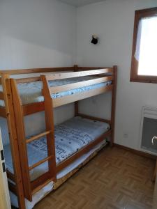 Ce dortoir comprend 2 lits superposés et une fenêtre. dans l'établissement Appartement 4/6 personnes Puy Saint Vincent, à Puy-Saint-Vincent