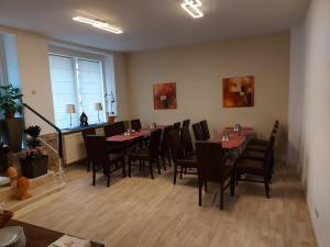 a dining room with tables and chairs and a window at Mabri Apartments Plauen in Plauen