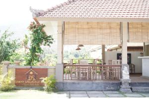 une maison avec une terrasse couverte dotée de tables et de chaises dans l'établissement Damar Sanjaya Uttama, à Amed