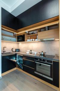 una cocina con armarios negros y electrodomésticos de acero inoxidable en TartuKodu Riia 20B-3, en Tartu