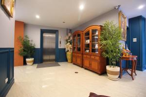 a hallway with potted plants and a wooden cabinet at Super OYO 484 Pannee Residence Khaosan Sha Plus in Bangkok