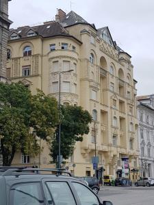 a large yellow building with cars parked in front of it at VIP Residence Budapest Riverside in Budapest