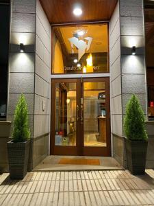 a front door of a building with two plants in front at Hotel Condes De Lemos España in Monforte de Lemos