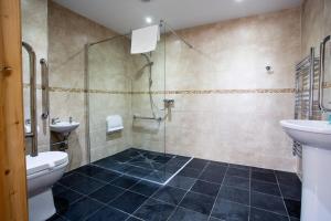 a bathroom with a shower and a toilet and a sink at The Windmill Inn in Watchet