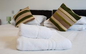 a pile of towels sitting on top of a bed at The Windmill Inn in Watchet