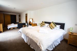 a bedroom with two large beds with white sheets at The Windmill Inn in Watchet