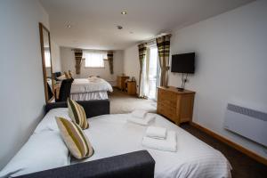 a hotel room with a bed and a tv at The Windmill Inn in Watchet