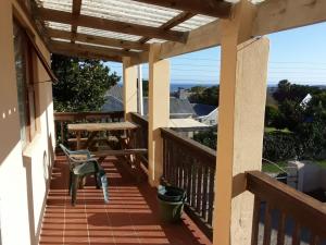 a balcony with a table and a bench on it at Yonz Self Catering Units in Port Alfred
