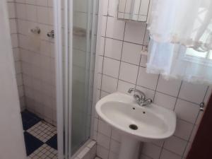 y baño blanco con lavabo y ducha. en Yonz Self Catering Units en Port Alfred