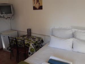 a room with a couch and a table and a tv at Yonz Self Catering Units in Port Alfred