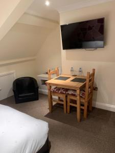 a room with a table and a tv and a bed at Castle house in Knaresborough