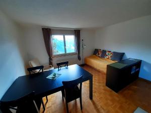 ein Wohnzimmer mit einem Tisch und einem Bett in der Unterkunft Apartment 2,5 Zimmer im Ferienhaus Damian in Braunwald