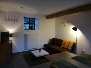 uma sala de estar com um sofá e uma mesa em Noest em Destelbergen