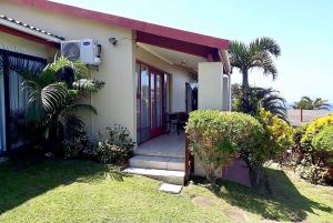 uma pequena casa com um alpendre e um pátio em Seaview on Shelly em Margate