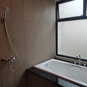 ein Badezimmer mit Dusche und Waschbecken und einem Fenster in der Unterkunft vila vimala hills in Bogor