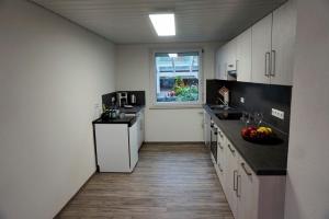 uma cozinha com armários brancos e uma janela em Ferienwohnung Auszeit Zwiefalten em Zwiefalten