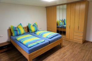 sypialnia z dużym niebieskim łóżkiem z kolorowymi poduszkami w obiekcie Ferienwohnung Auszeit Zwiefalten w mieście Zwiefalten