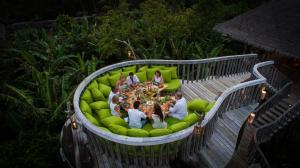 a group of people sitting on a circular couch at Soneva Fushi in Baa Atoll