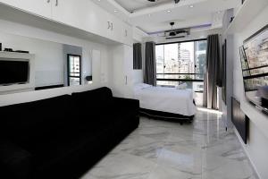 ein Wohnzimmer mit einem Sofa und einem Bett in der Unterkunft Studio moderno com vista privilegiada para a praia in Rio de Janeiro
