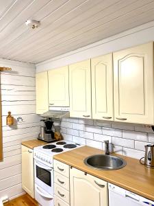 a kitchen with white cabinets and a sink at Playa del Finland in Peräseinäjoki