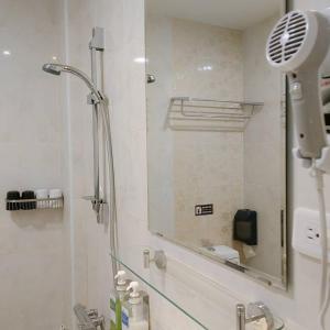 W łazience znajduje się prysznic z lustrem. w obiekcie Top Bay B&B w mieście Donggang