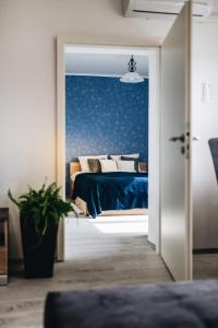 1 dormitorio con 1 cama con sábanas y almohadas azules en Magas-lak Apartman Eger, en Eger