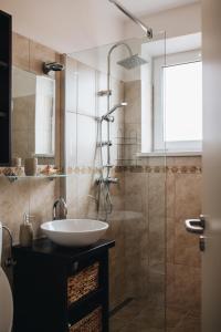 La salle de bains est pourvue d'un lavabo et d'une douche. dans l'établissement Magas-lak Apartman Eger, à Eger