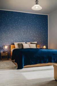 a blue bedroom with a bed with a blue wall at Magas-lak Apartman Eger in Eger