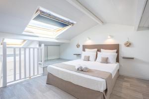 a bedroom with a large bed and a skylight at Appartement Marineland Sea View in Antibes